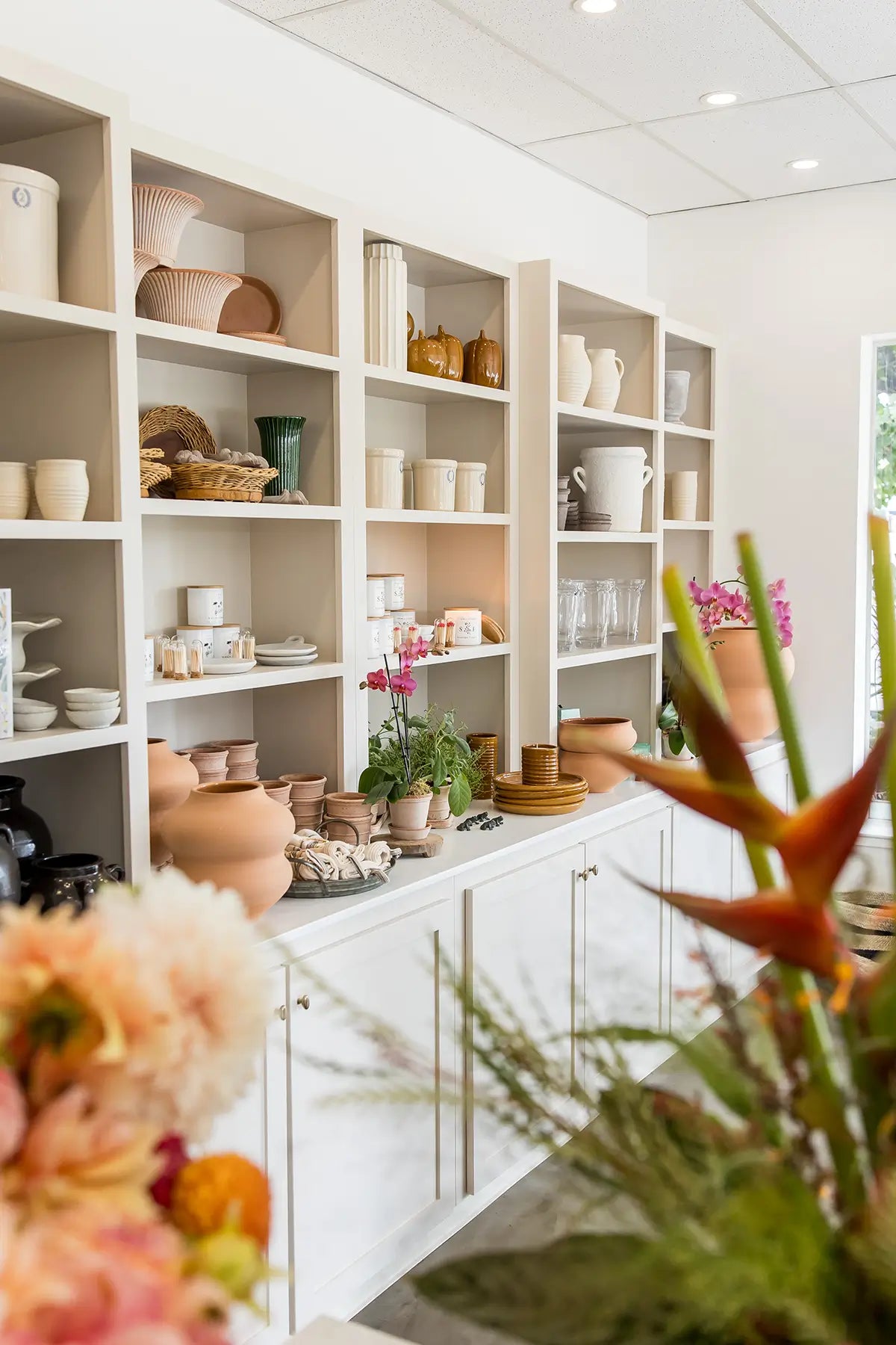 Image of pots and home decor on shelves inside Seascape Flowers Aptos flower shop