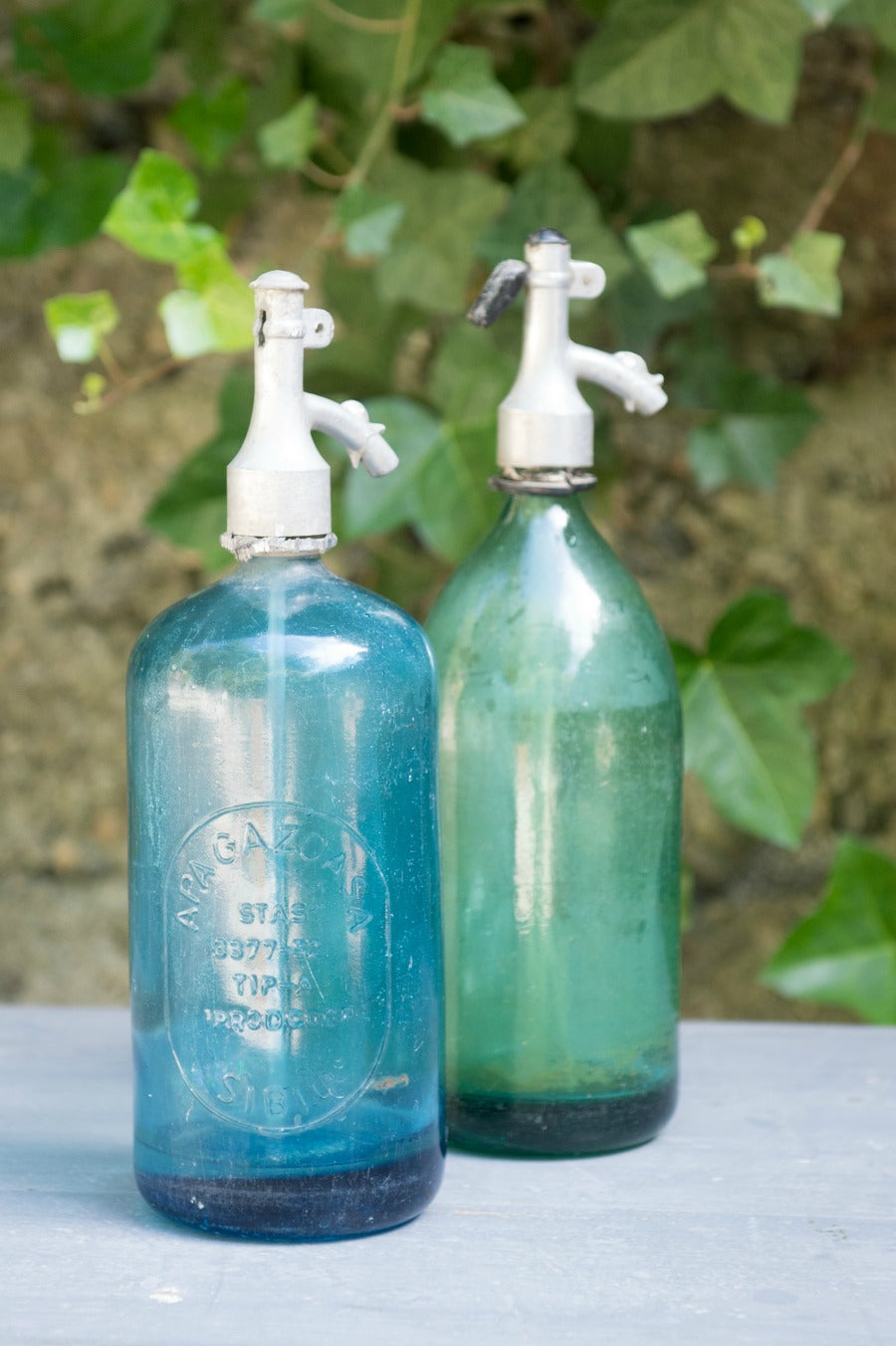 vintage seltzer bottles in green and blue